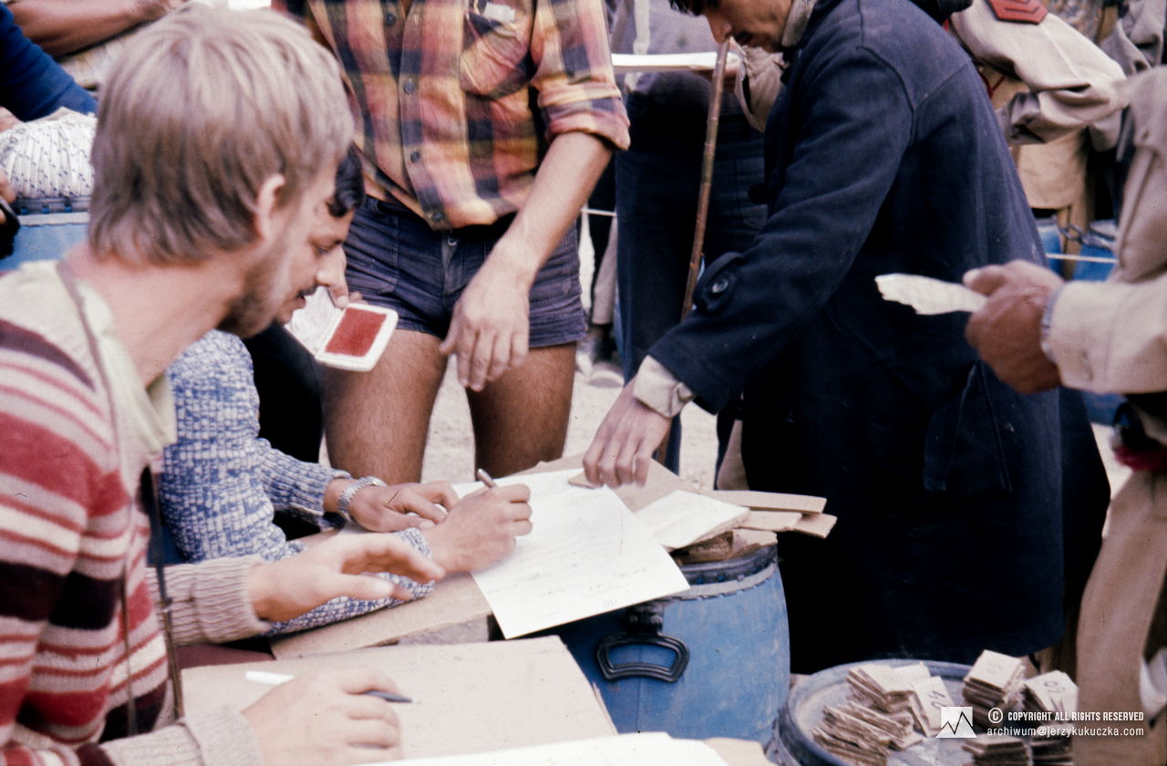 Allocation of cargo to porters. In the foreground from left: Wojciech Dzik and Shoaib Hameed.
