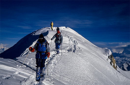 “Kiedy zaświeciło słońce, wszyscy nagle, jak na komendę, zupełnie niczym stawka koni, gdy bomba idzie w górę, ruszyli. Byle tylko zdążyć, bo przecież pogoda może zmienić się w każdej chwili”. Na pierwszym planie Elsa Avila, za nią kolejno: Carlos Carsolio, Artur Hajzer i Wanda Rutkiewicz.