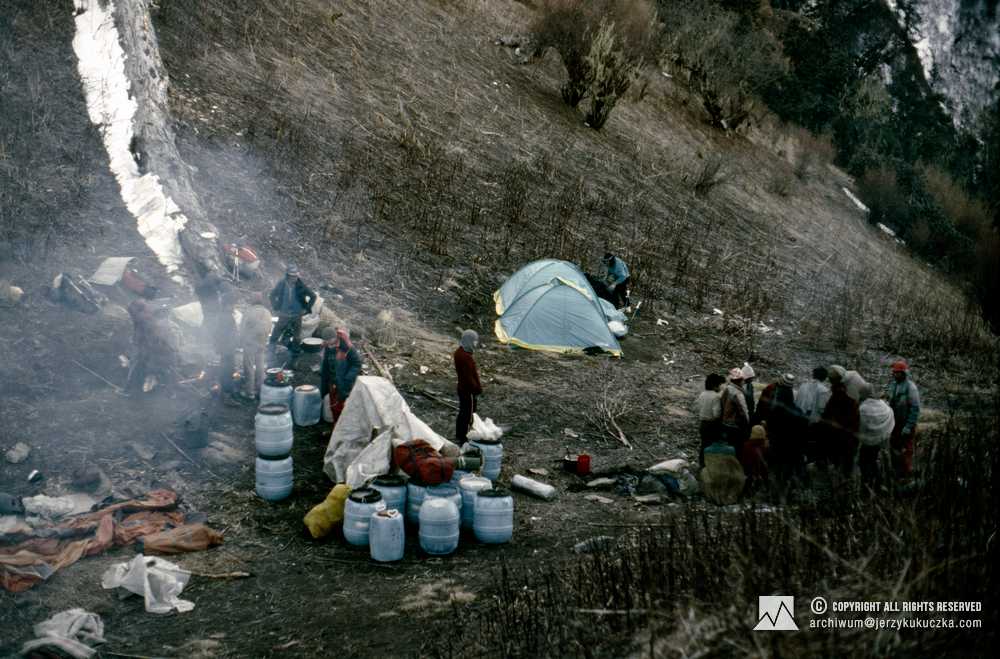 Dojście do bazy. Przy niebieskich namiotach Wanda Rutkiewicz, przy beczkach w brązowym swetrze stoi Artur Hajzer.