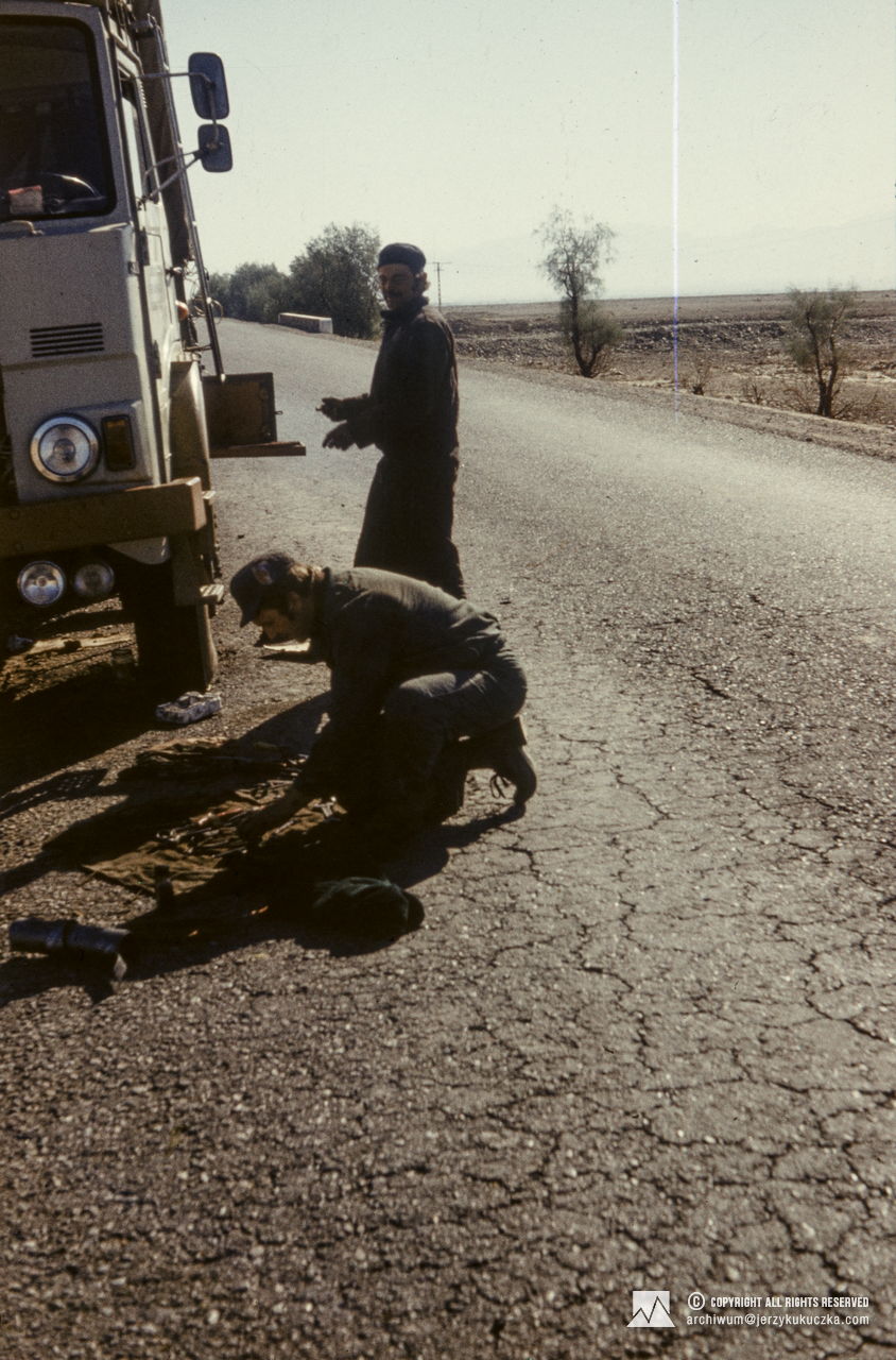 Participants of the expedition during the repair of a truck in Afghanistan. Adam Zyzak is standing, Wiesław Lipiński is crouching. Return of the participants of the expedition to Poland. Route from Islamabad to Katowice.