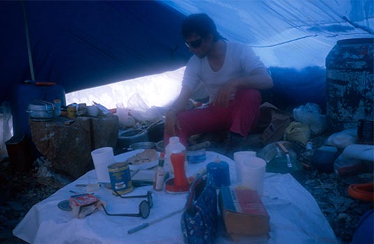 Wojciech Kurtyka otoczony kuchennym asortymentem w bazie.