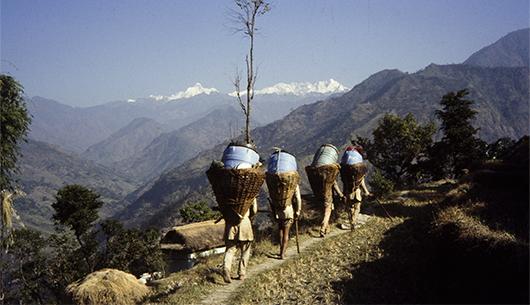 Tragarze w drodze do bazy. W tle masyw Kangchenjungi.